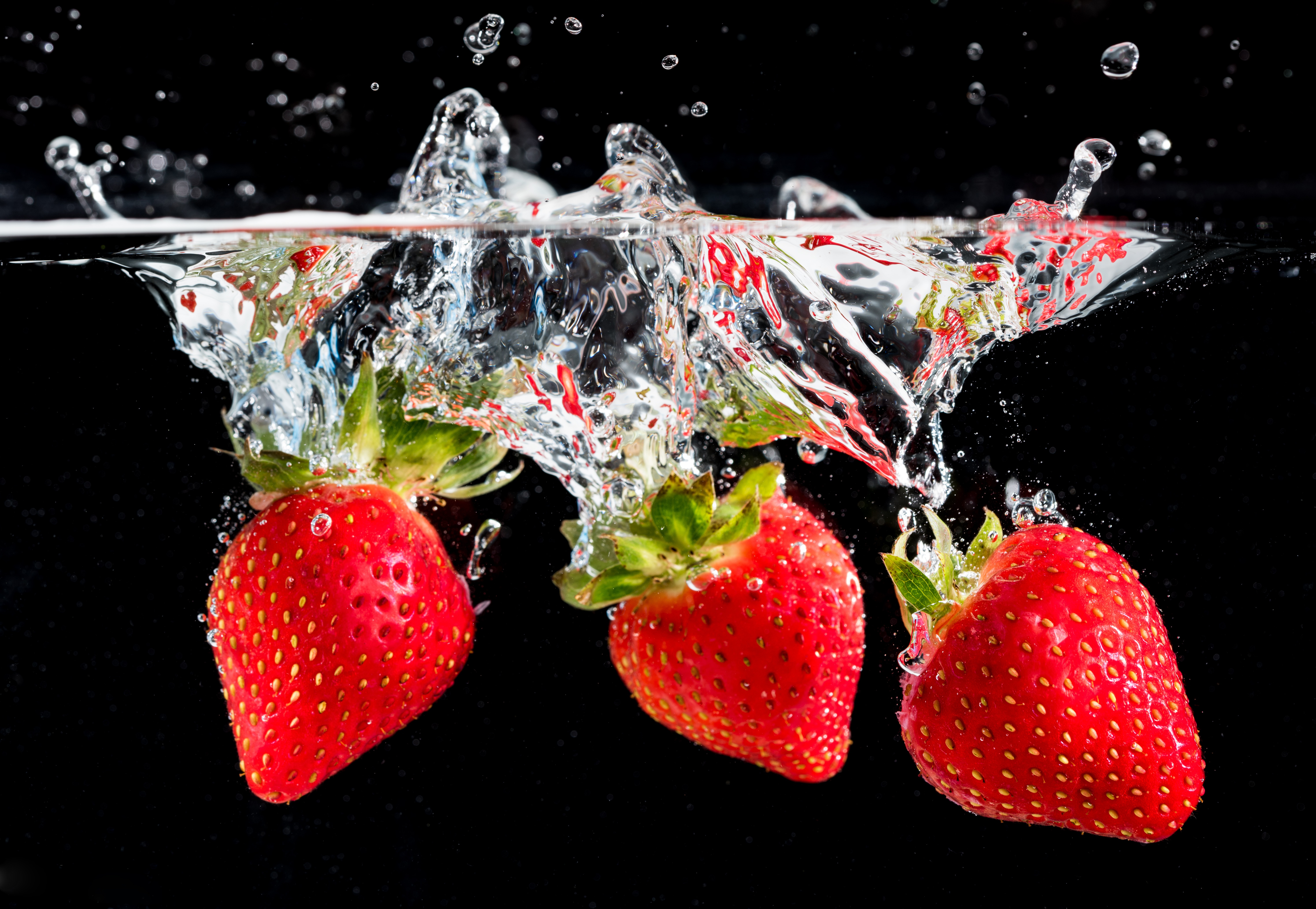 Три ягоды клубники в воде